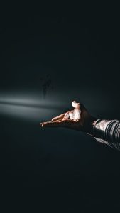 A person at peace, hands at rest in soft natural light, relief in their face